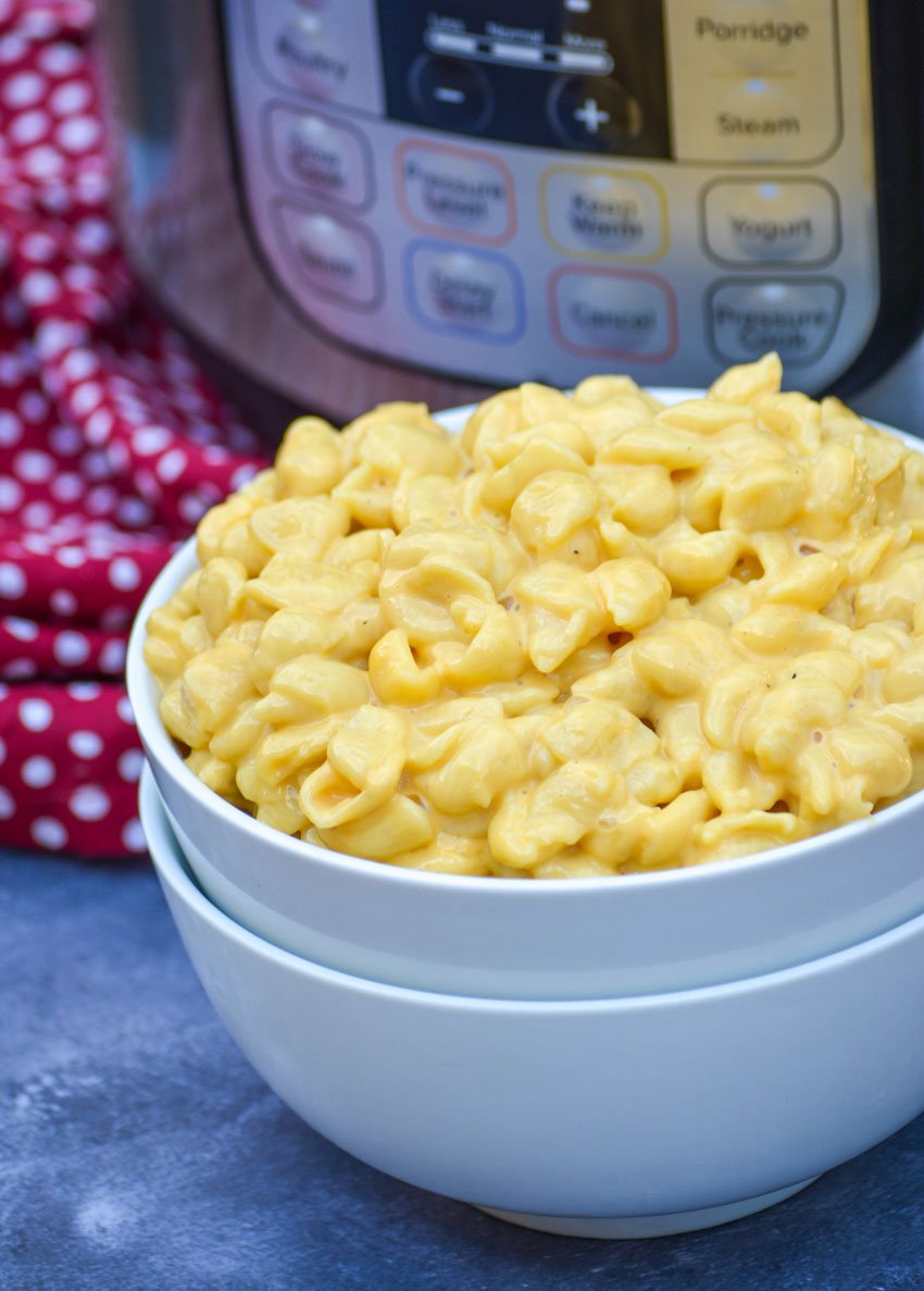 Instant Pot shells and cheese in a white bowl in front of an instant pot