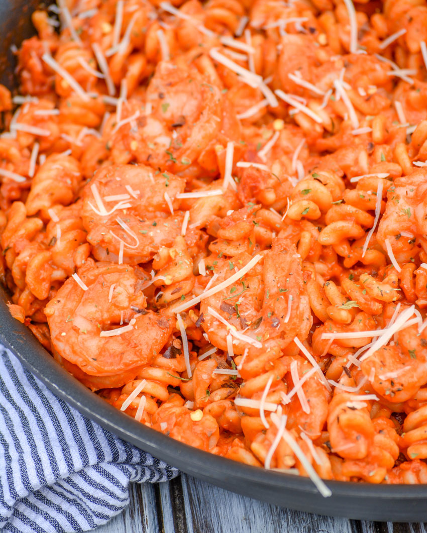 creamy shrimp tomato pasta in a black skillet