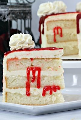 A SLICE OF BLOODY VAMPIRE LAYER CAKE ON A SMALL WHITE DESSERT PLATE