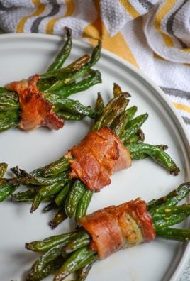 bacon wrapped green bean bundles on a white plate