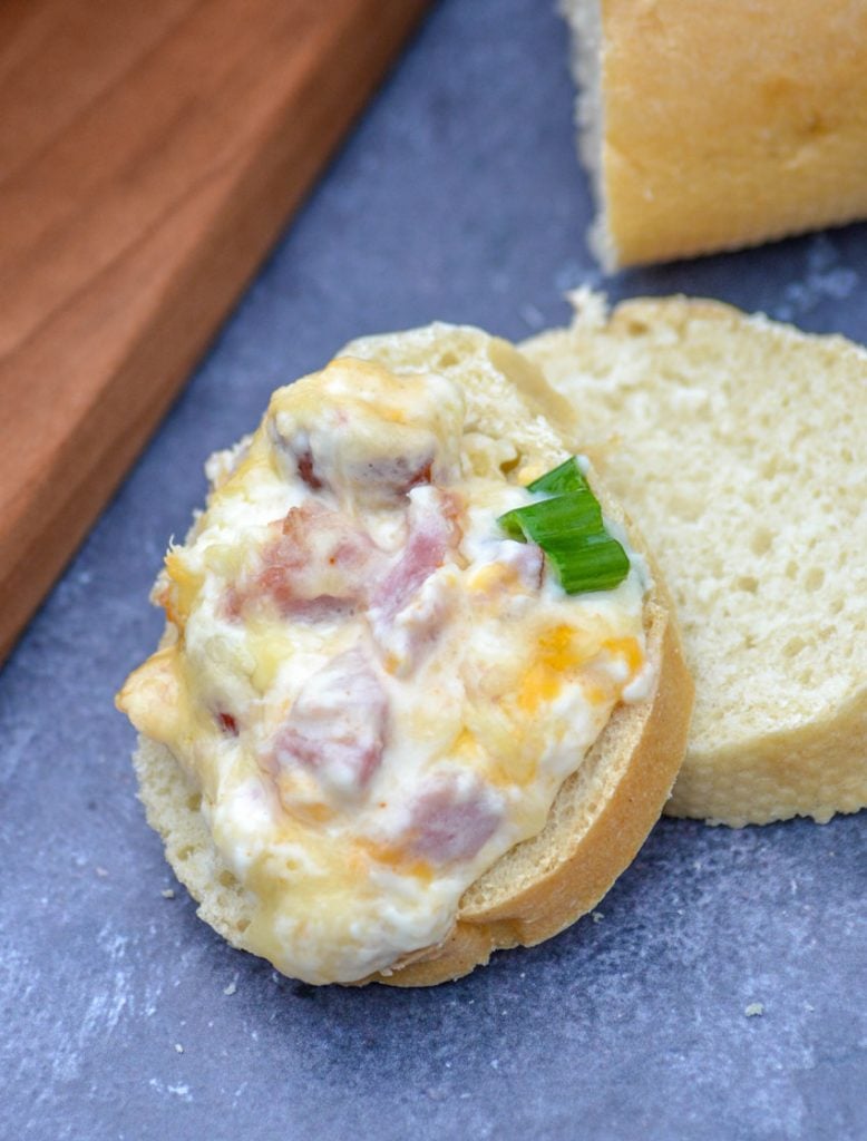 creamy hot ham & Swiss dip is pictured on freshly sliced baguette