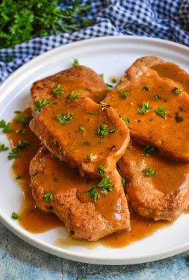 instant pot pork chops topped with brown gravy on a white plate