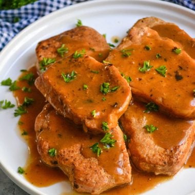 instant pot pork chops topped with brown gravy on a white plate