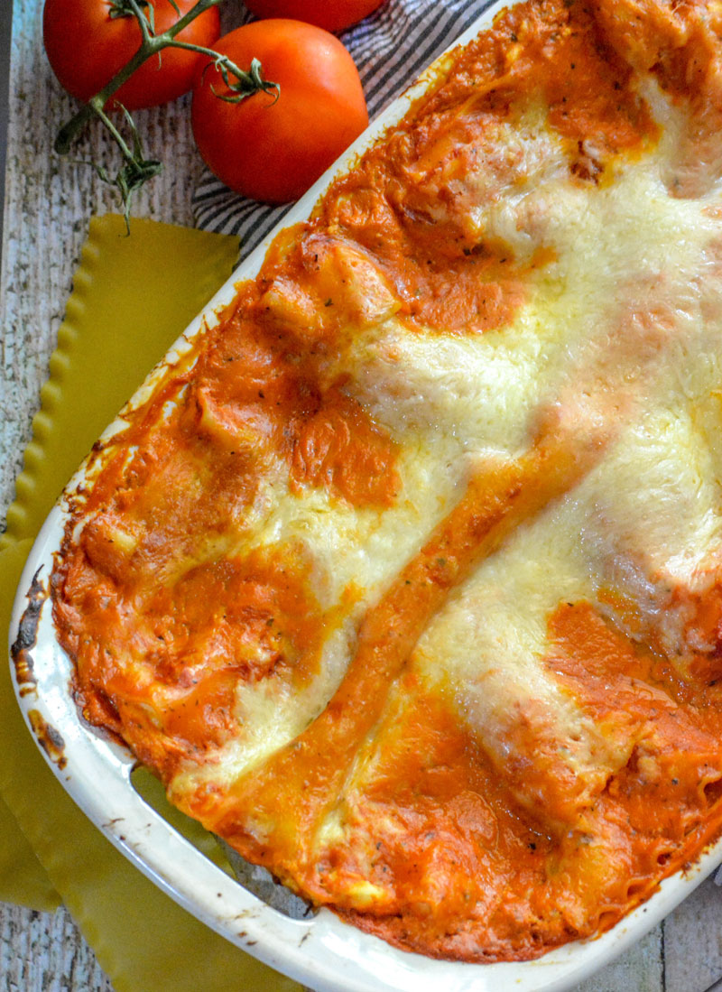 lasagna with a blush sauce in a white casserole dish