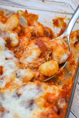 a silver spoon scooping pepperoni pizza gnocchi bake out of a glass casserole dish