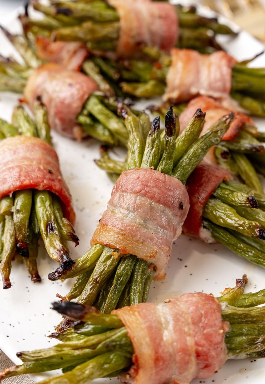 bacon wrapped green bean bundles on a white serving platter