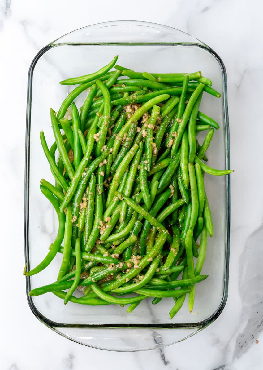 marinaded blanched green beans in a glass baking dish