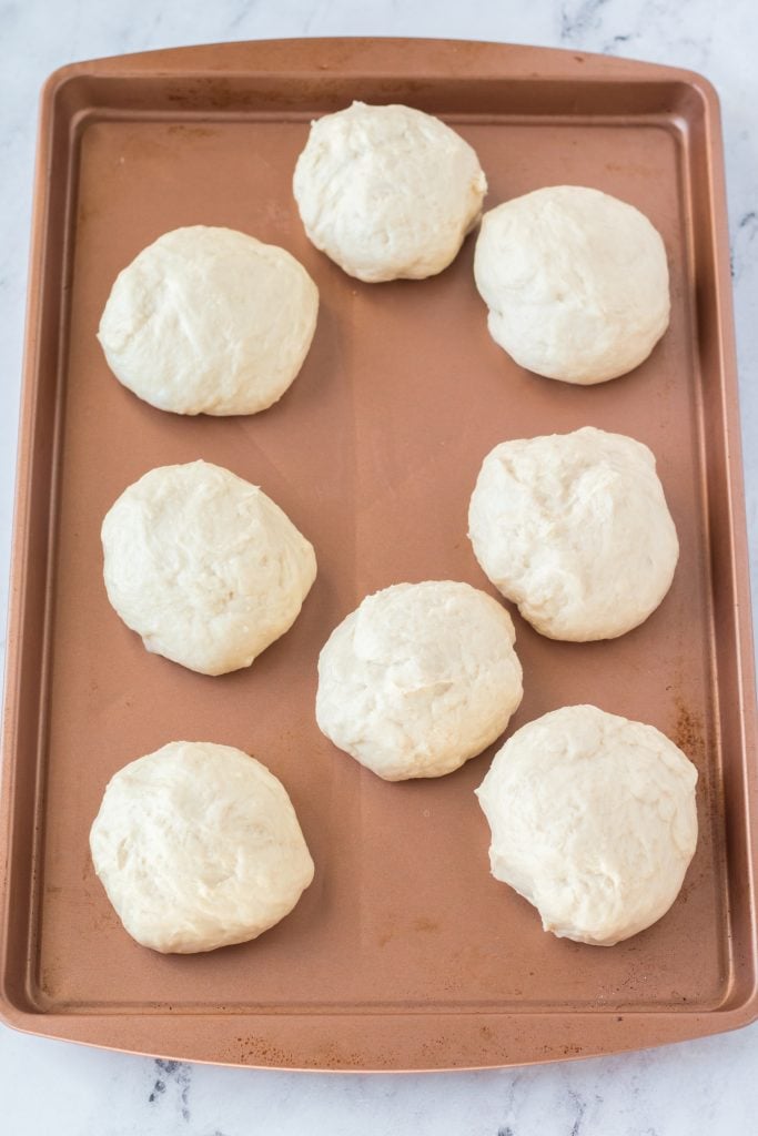 dough balls arranged on a metal baking sheet