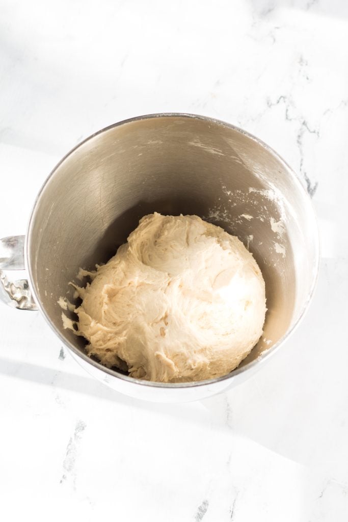 a ball of dough for homemade english muffins in a metal mixing bowl