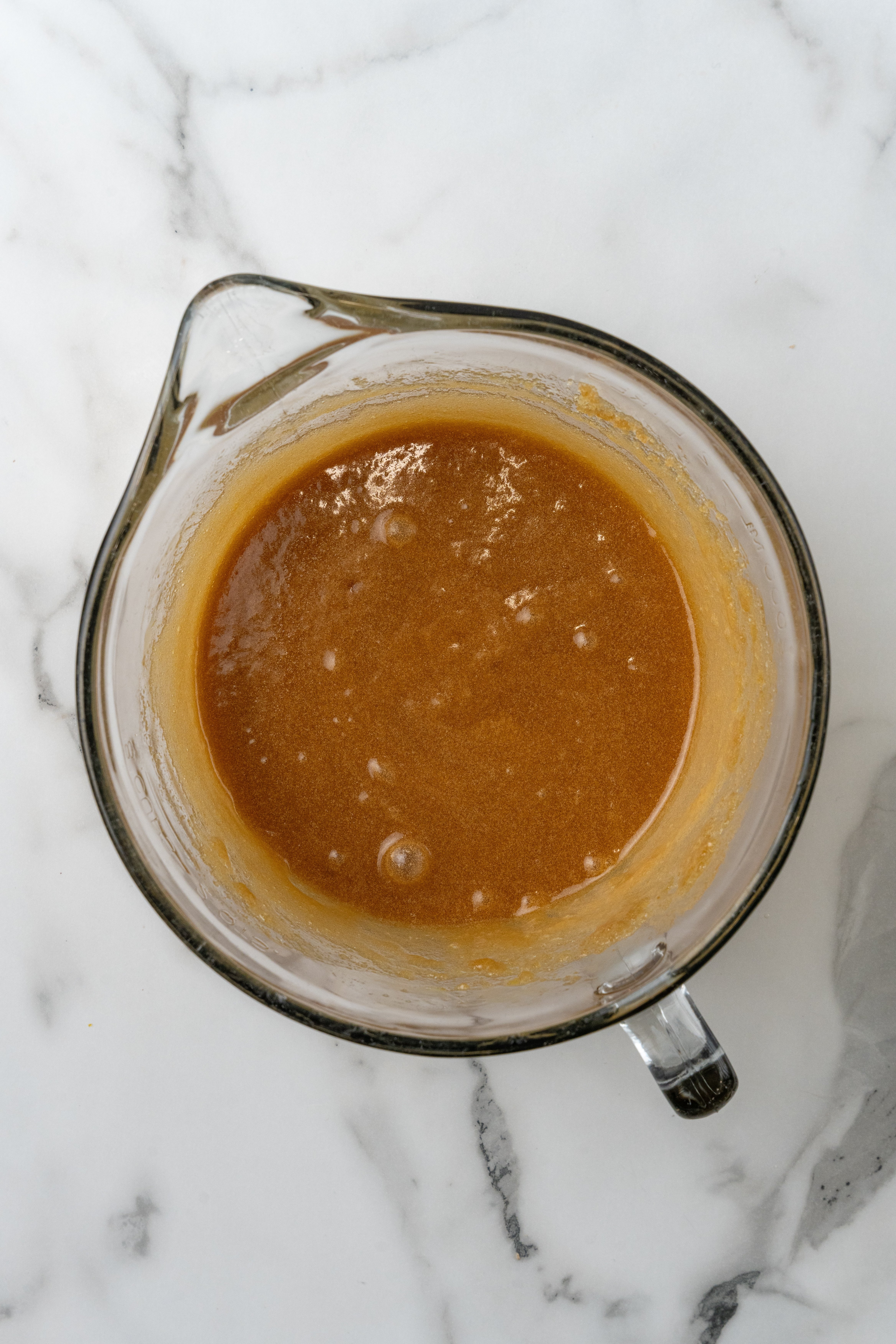 browned butter and beaten egg mixed together in a glass measuring jar