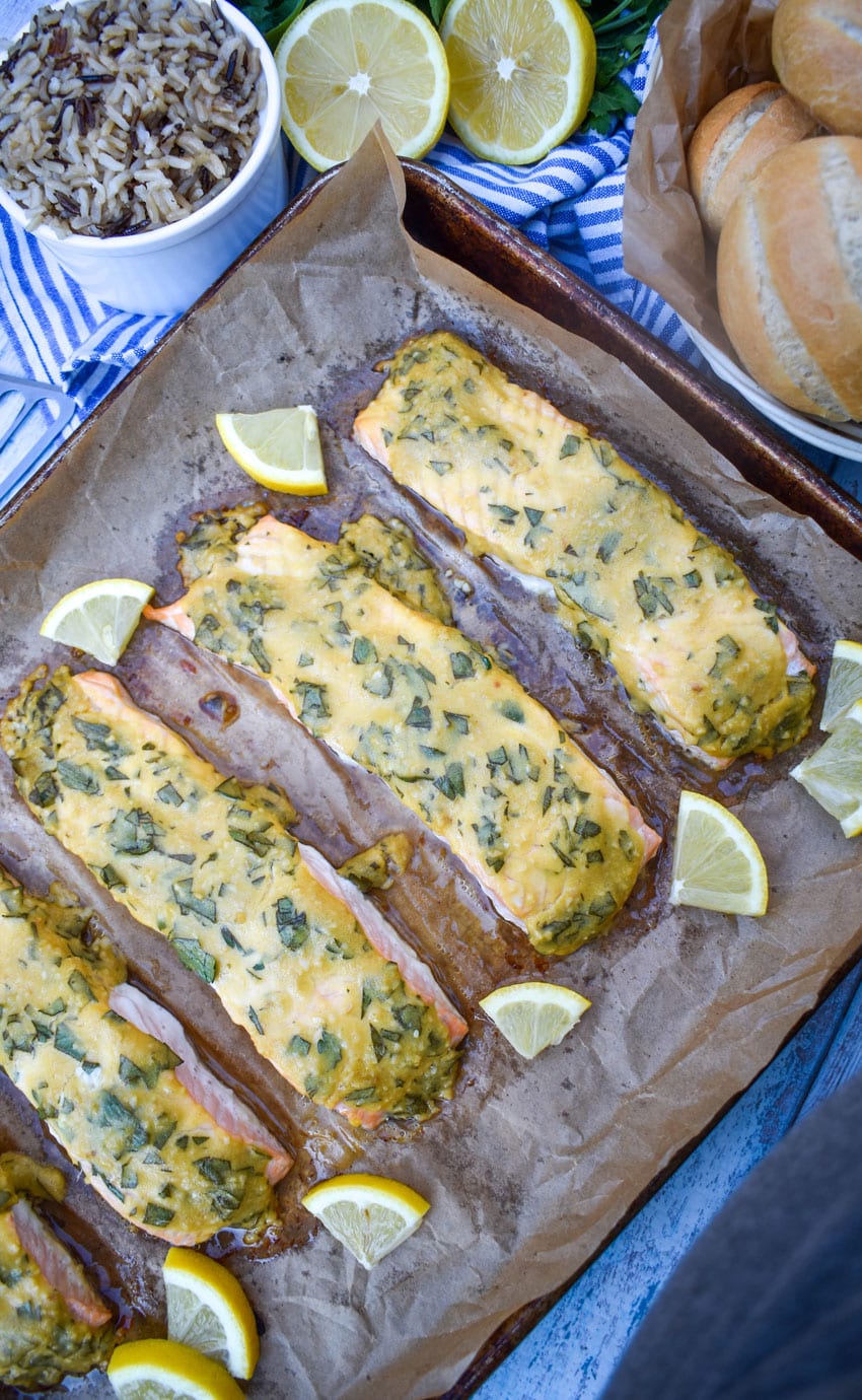 pieces of dijon mustard salmon on a parchment paper lined baking sheet