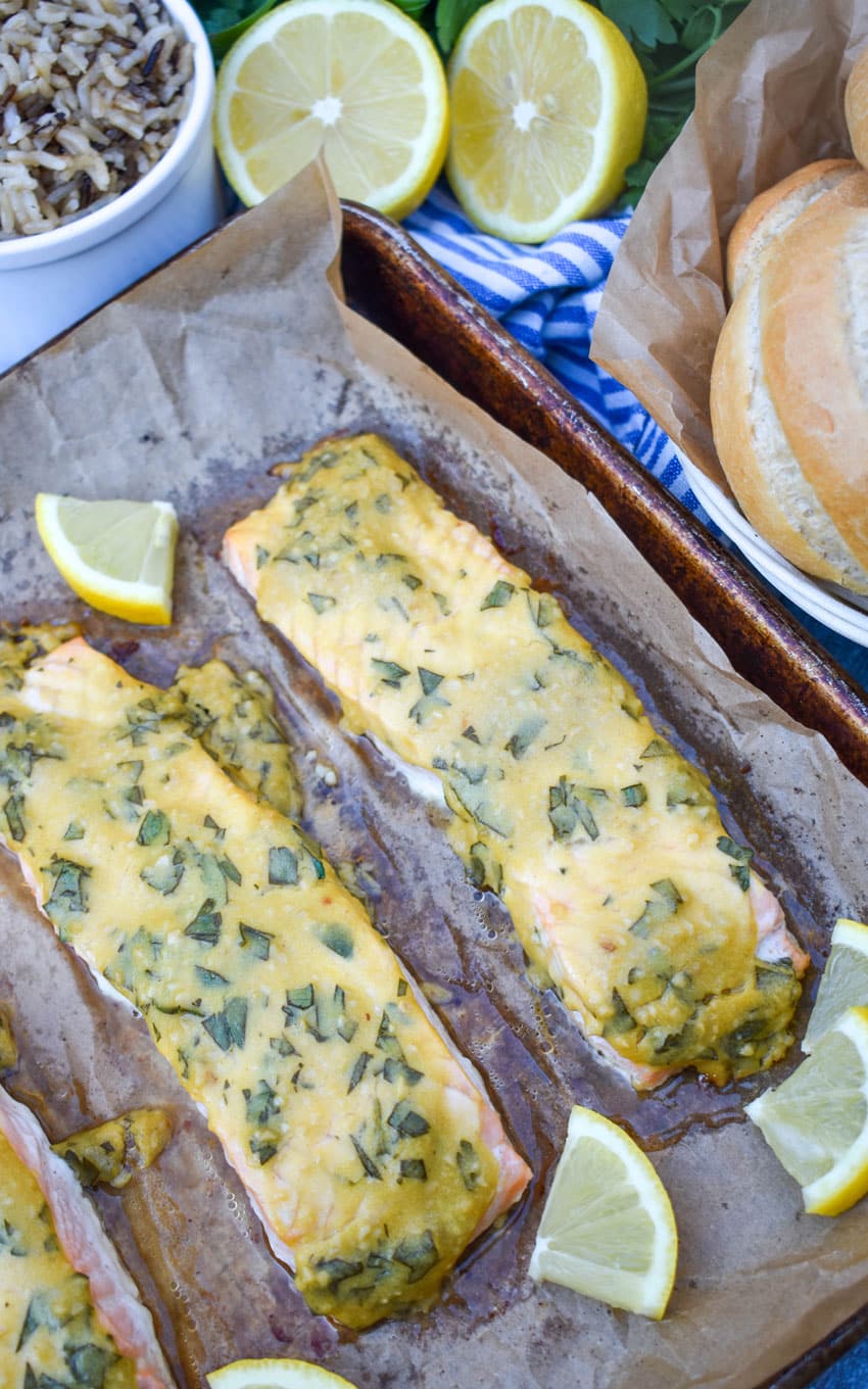 pieces of dijon mustard salmon on a parchment paper lined baking sheet