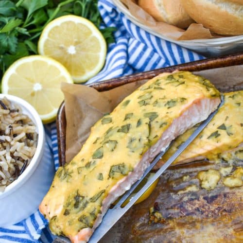 a spatula holding up a piece of dijon mustard salmon