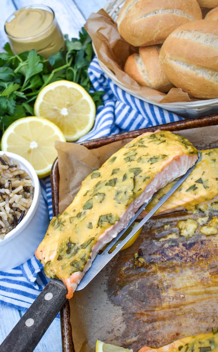 a spatula holding up a piece of dijon mustard salmon