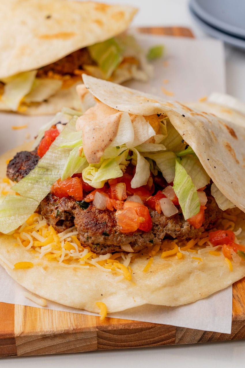 copycat applebee's quesadilla burgers on a parchment paper lined cutting board