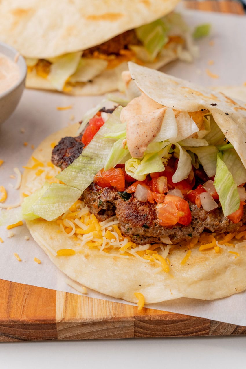 copycat applebee's quesadilla burgers on a parchment paper lined cutting board