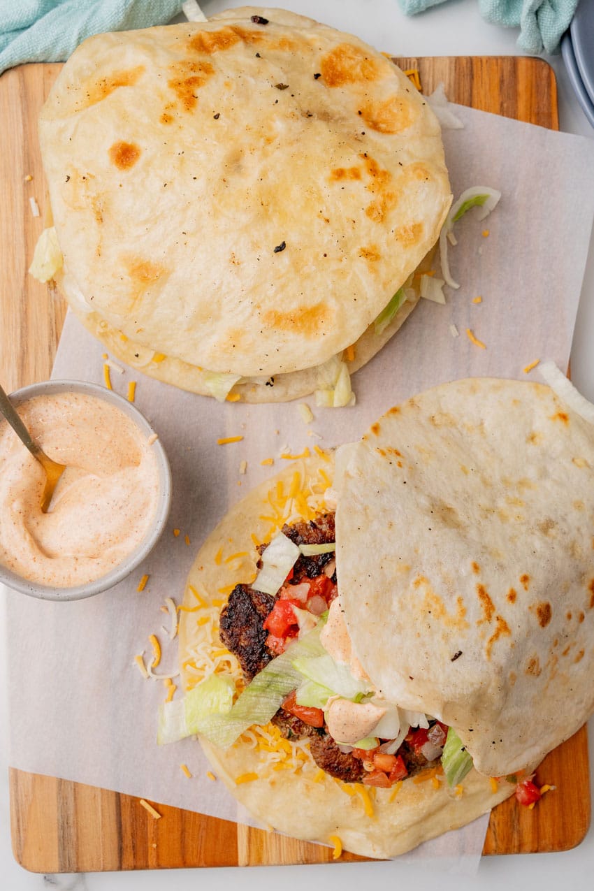 copycat applebee's quesadilla burgers on a parchment paper lined cutting board