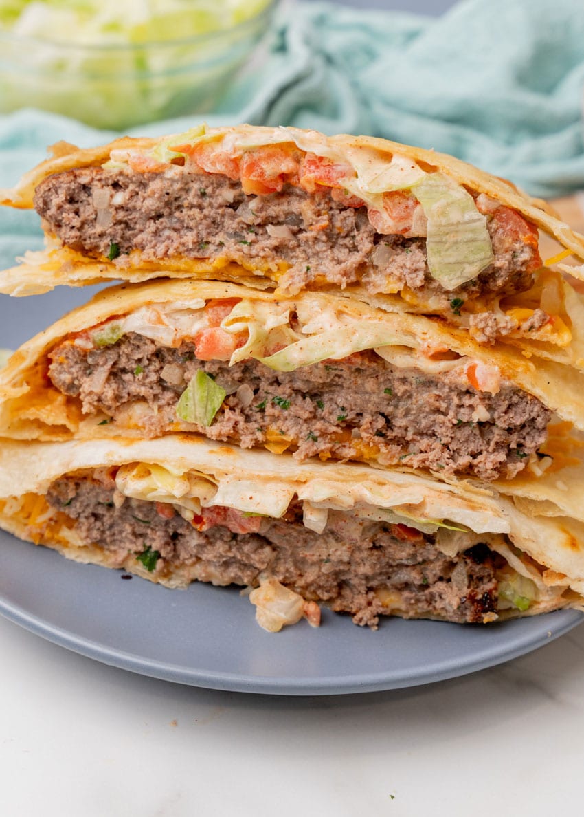 a stack of three quesadilla burger halves on a blue plate