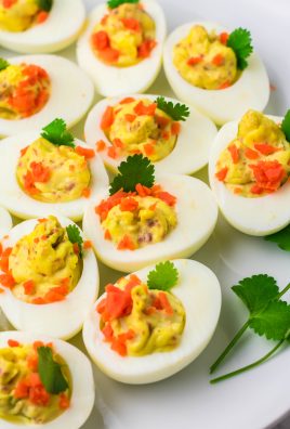 Irish deviled eggs on arranged on a white platter with fresh herbs