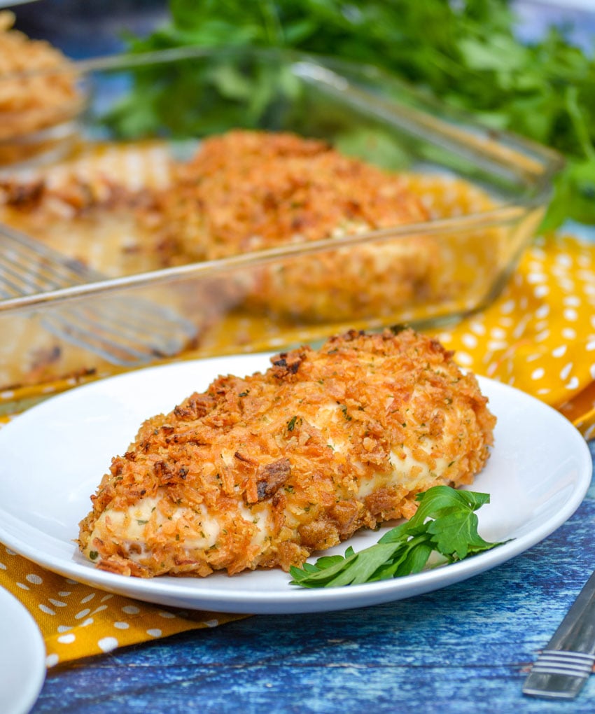 onion crusted herbed chicken on a white plate with fresh parsley leaves