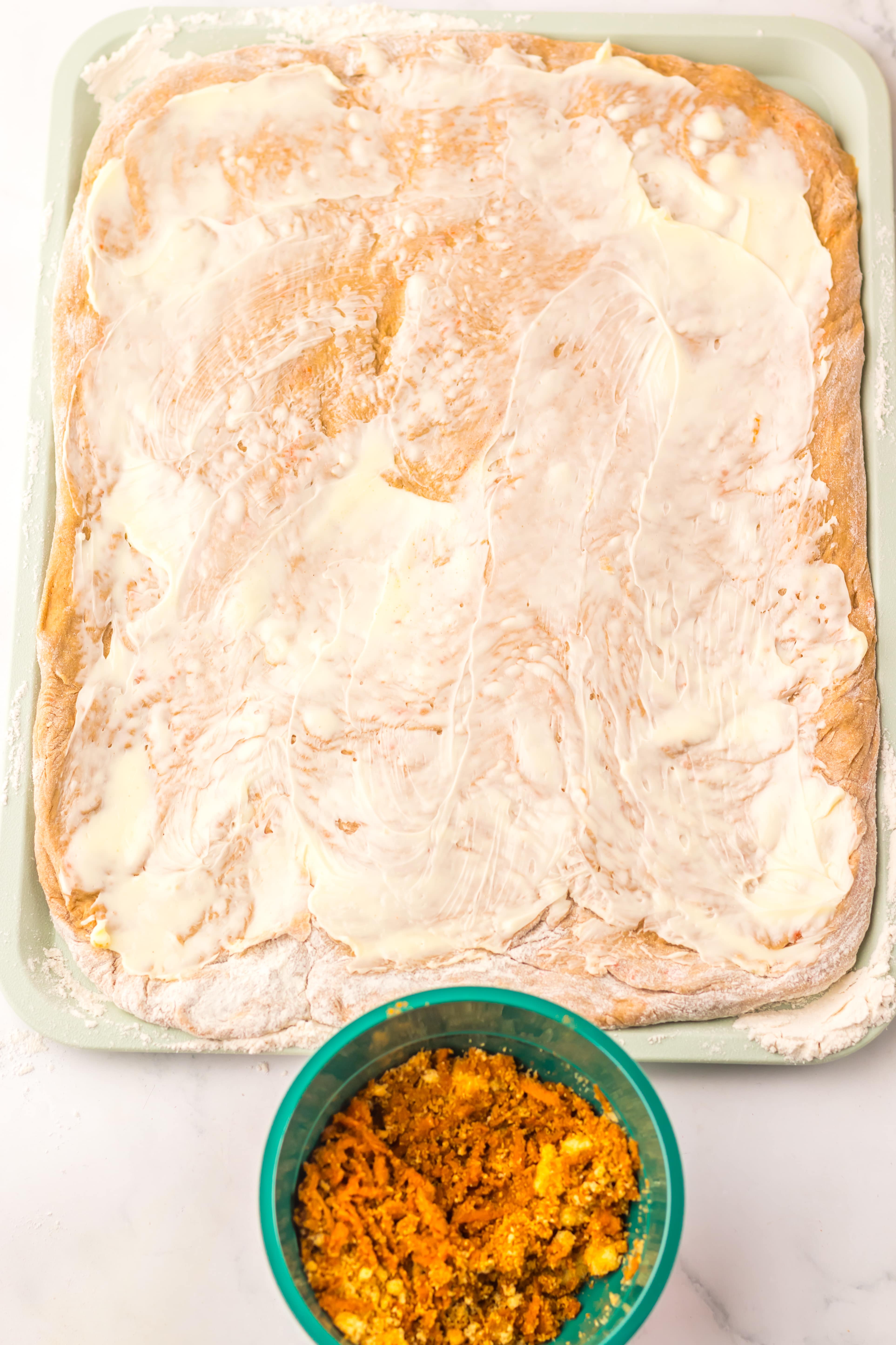 rolled out carrot cake cinnamon roll dough spread with softened butter