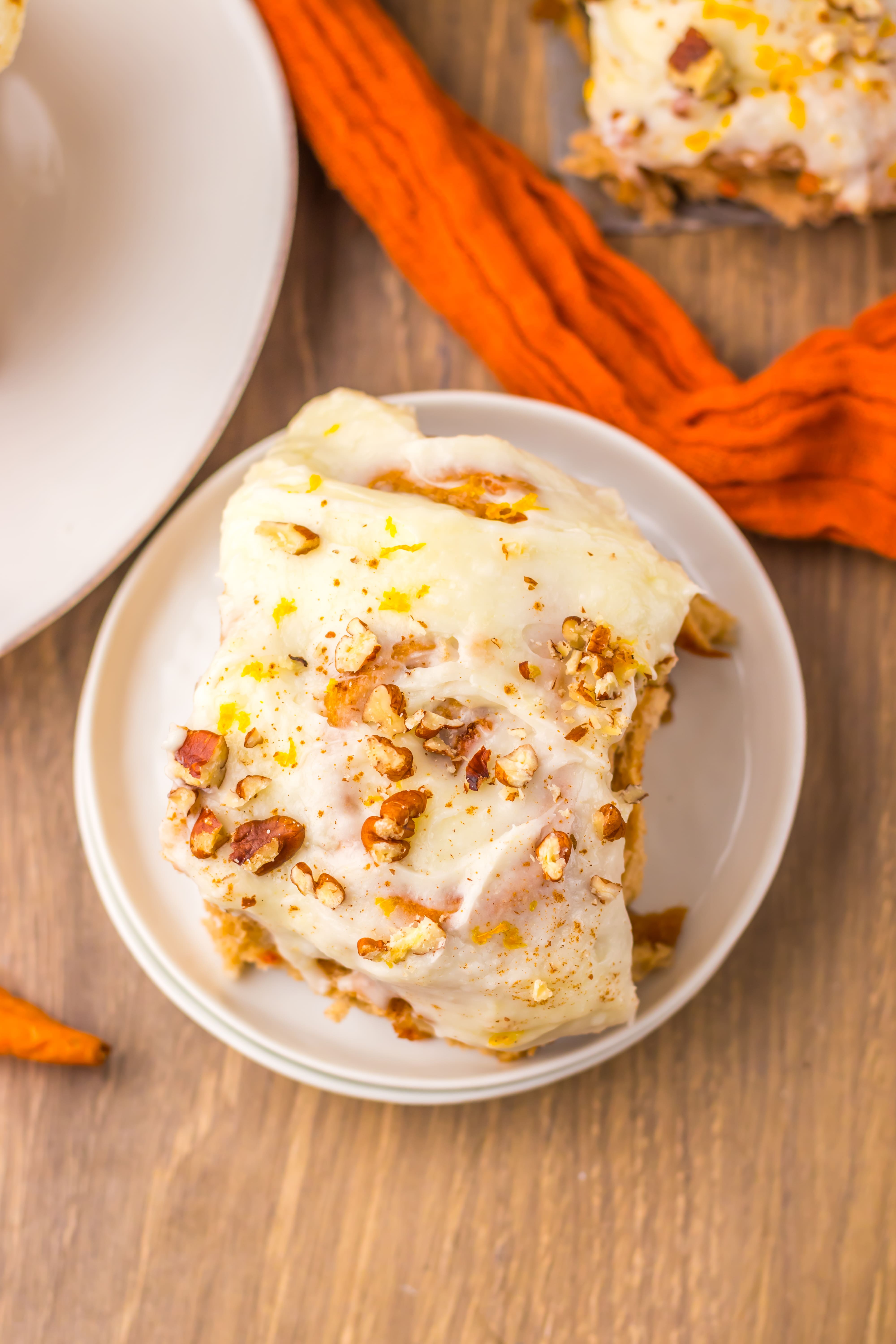 carrot cake cinnamon roll on a small white dessert plate