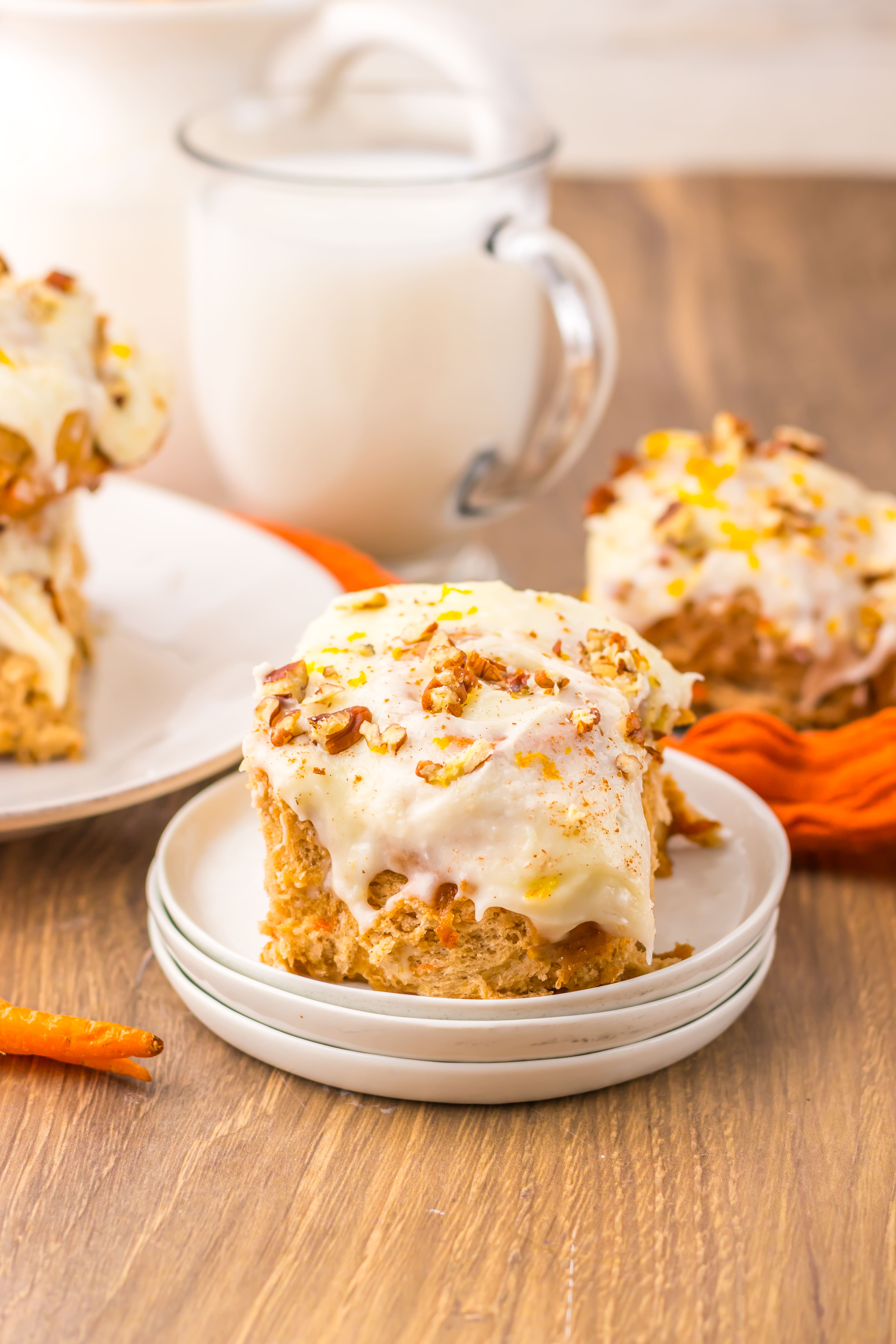 carrot cake cinnamon roll on a small white dessert plate