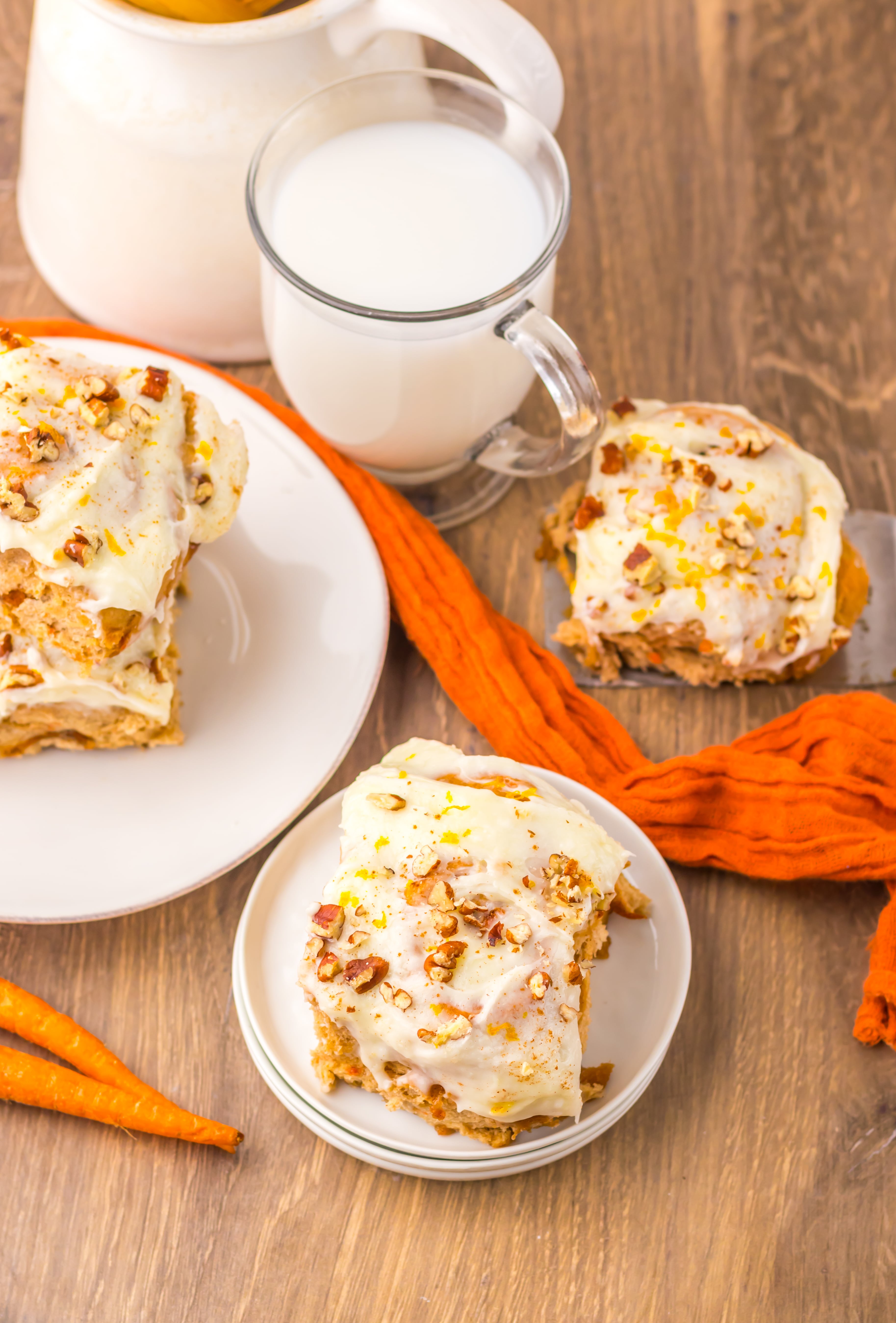 carrot cake cinnamon roll on a small white dessert plate