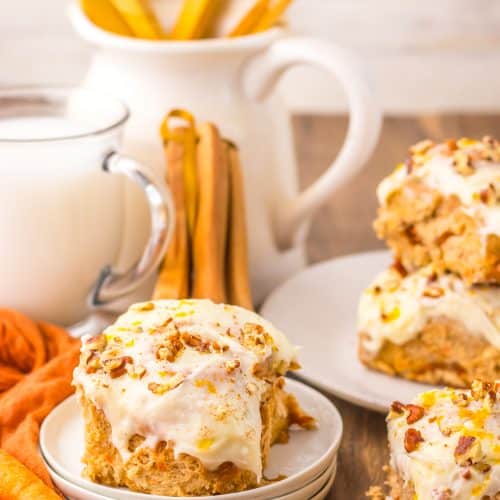 carrot cake cinnamon roll on a small white dessert plate