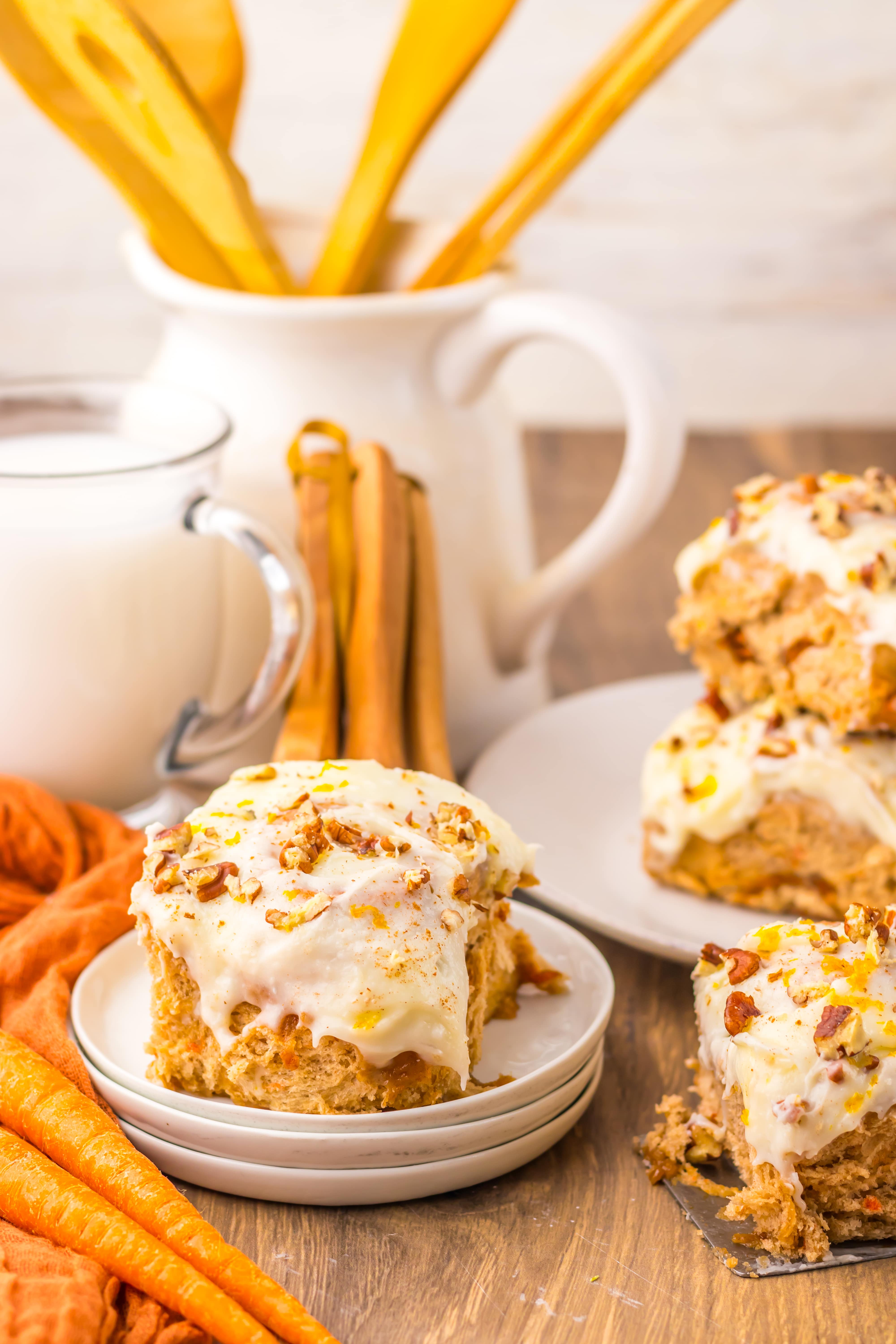 carrot cake cinnamon roll on a small white dessert plate