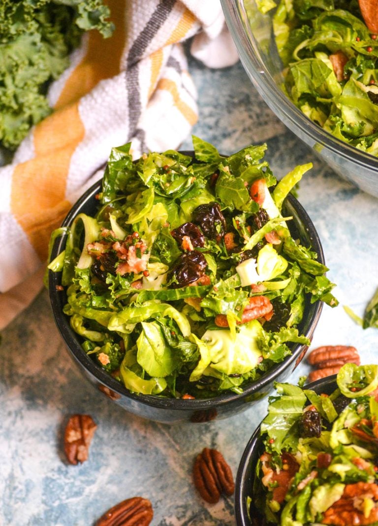 CRANBERRY KALE BRUSSELS SPROUT SALAD IN TWO SMALL BLACK BOWLS