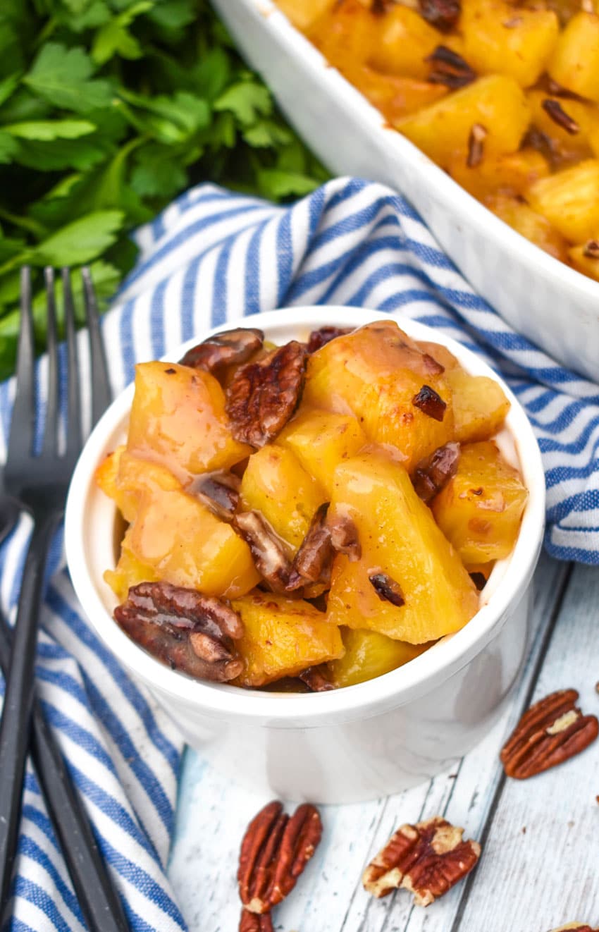 brown sugar roasted pineapples with pecan pieces in a small white bowl