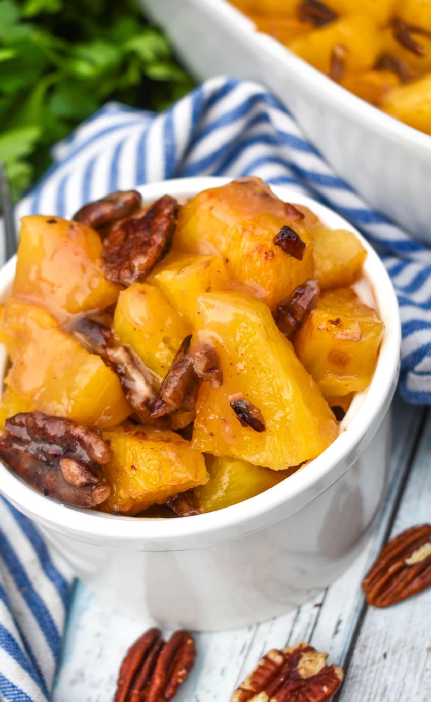 brown sugar roasted pineapples with pecan pieces in a small white bowl