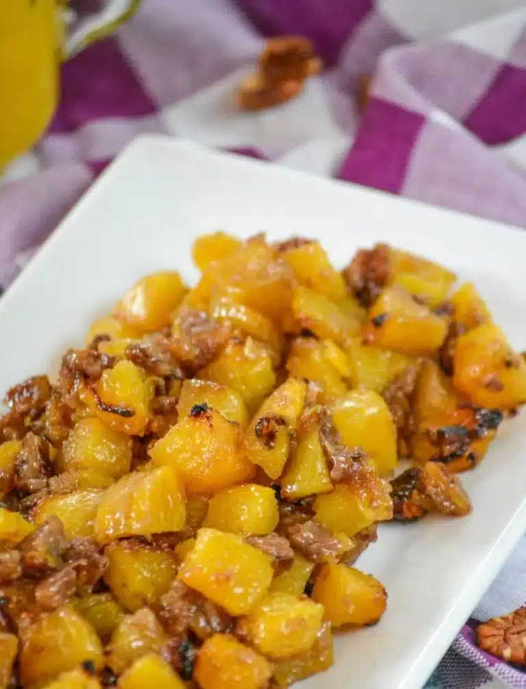 caramelized brown sugar pineapple chunks with nuts on a white serving platter