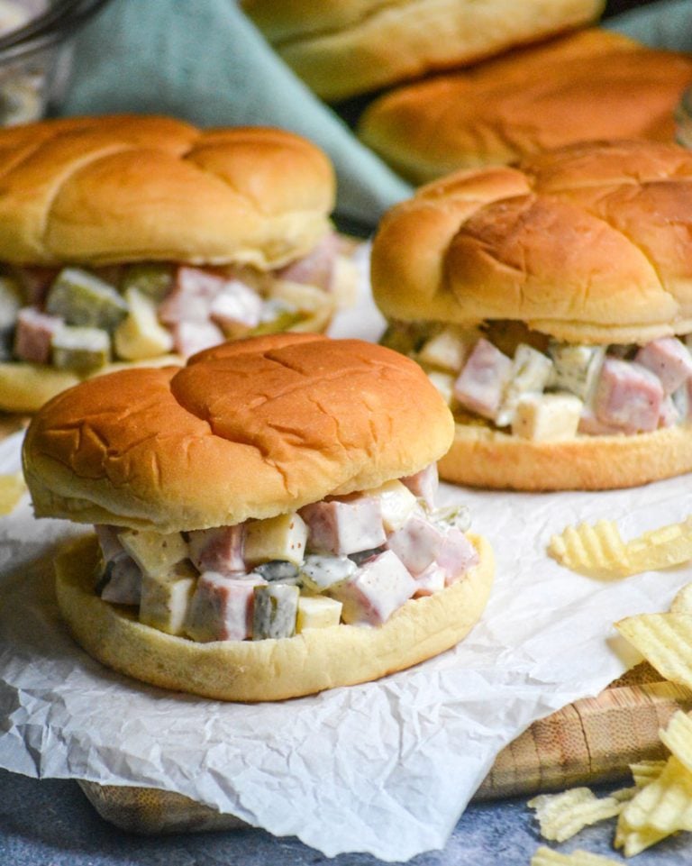 CUBAN HAM SALAD SANDWICHES ON A WRINKLED SHEET OF WHITE PARCHMENT PAPER