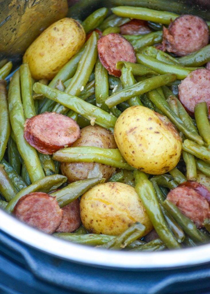 green beans, whole little potatoes, and thinly sliced smoked sausage in a pressure cooker after cooking