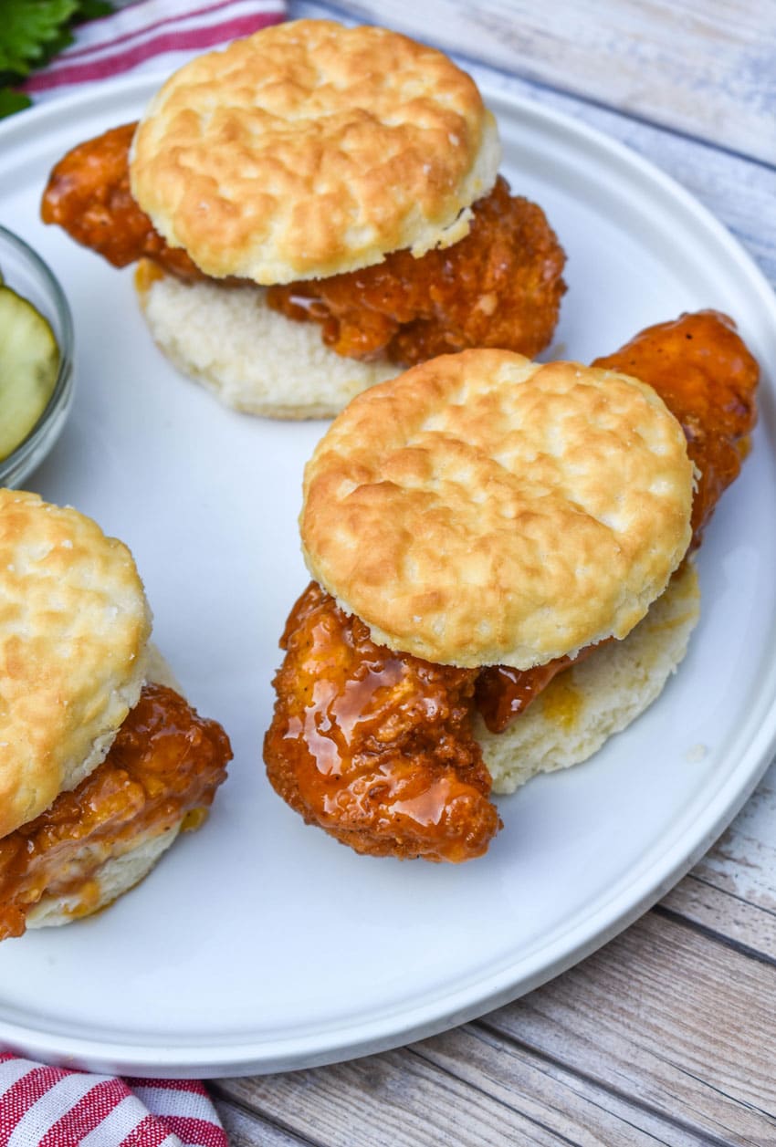 hot honey chicken biscuit sandwiches on a white plate