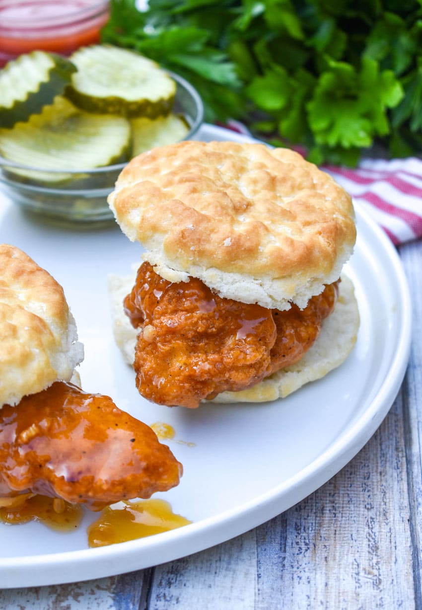 hot honey chicken biscuit sandwiches on a white plate