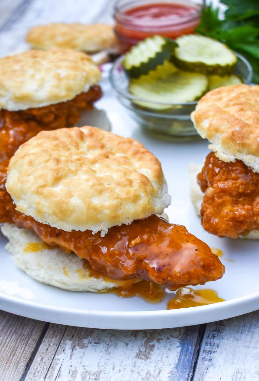 hot honey chicken biscuit sandwiches on a white plate