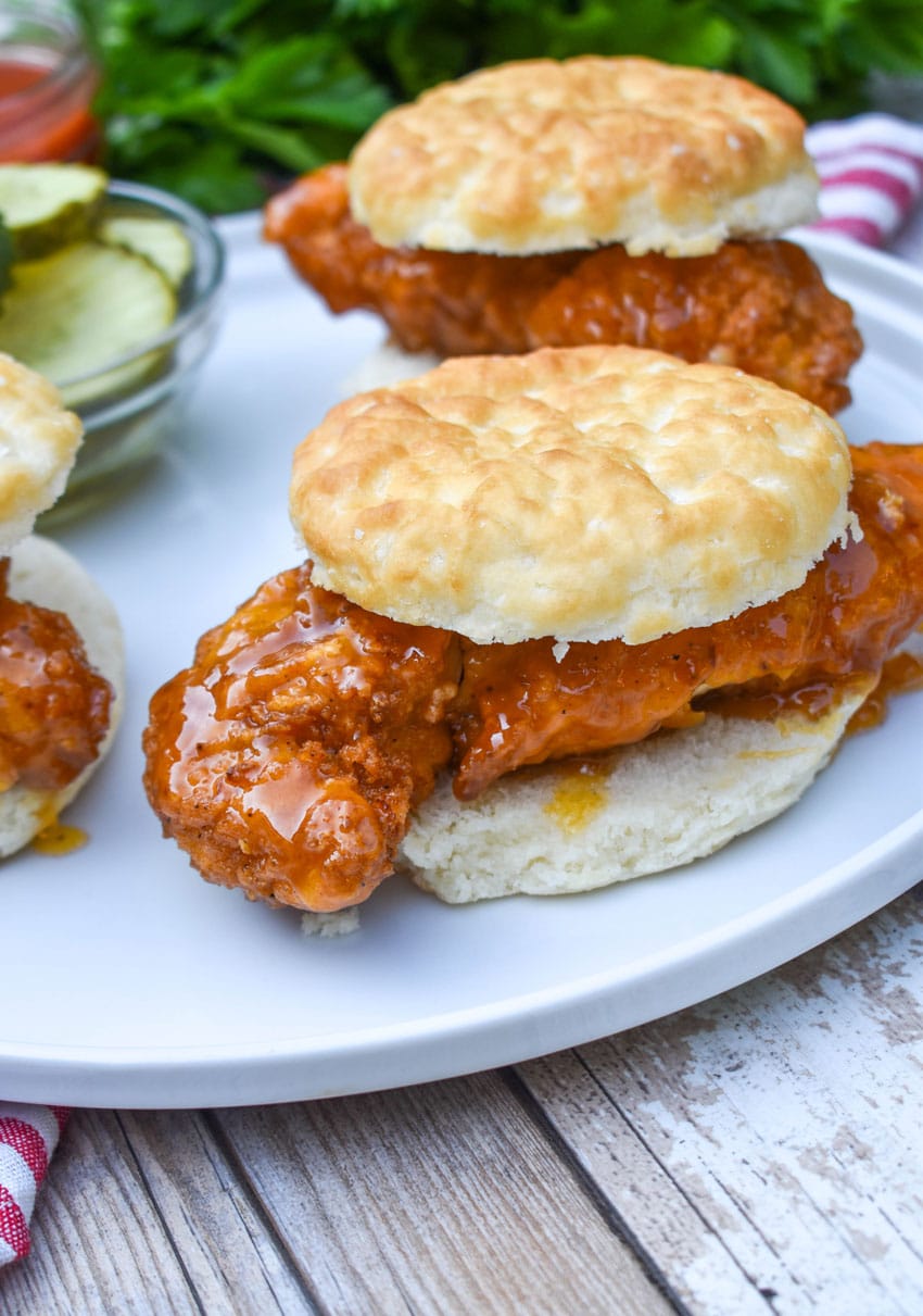 hot honey chicken biscuit sandwiches on a white plate