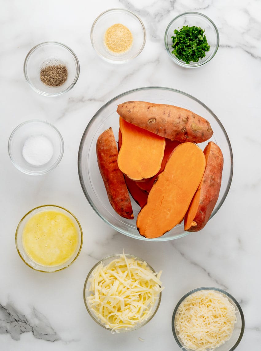an overhead image showing the measured ingredients needed to make a batch of cheesy garlic roasted sweet potatoes