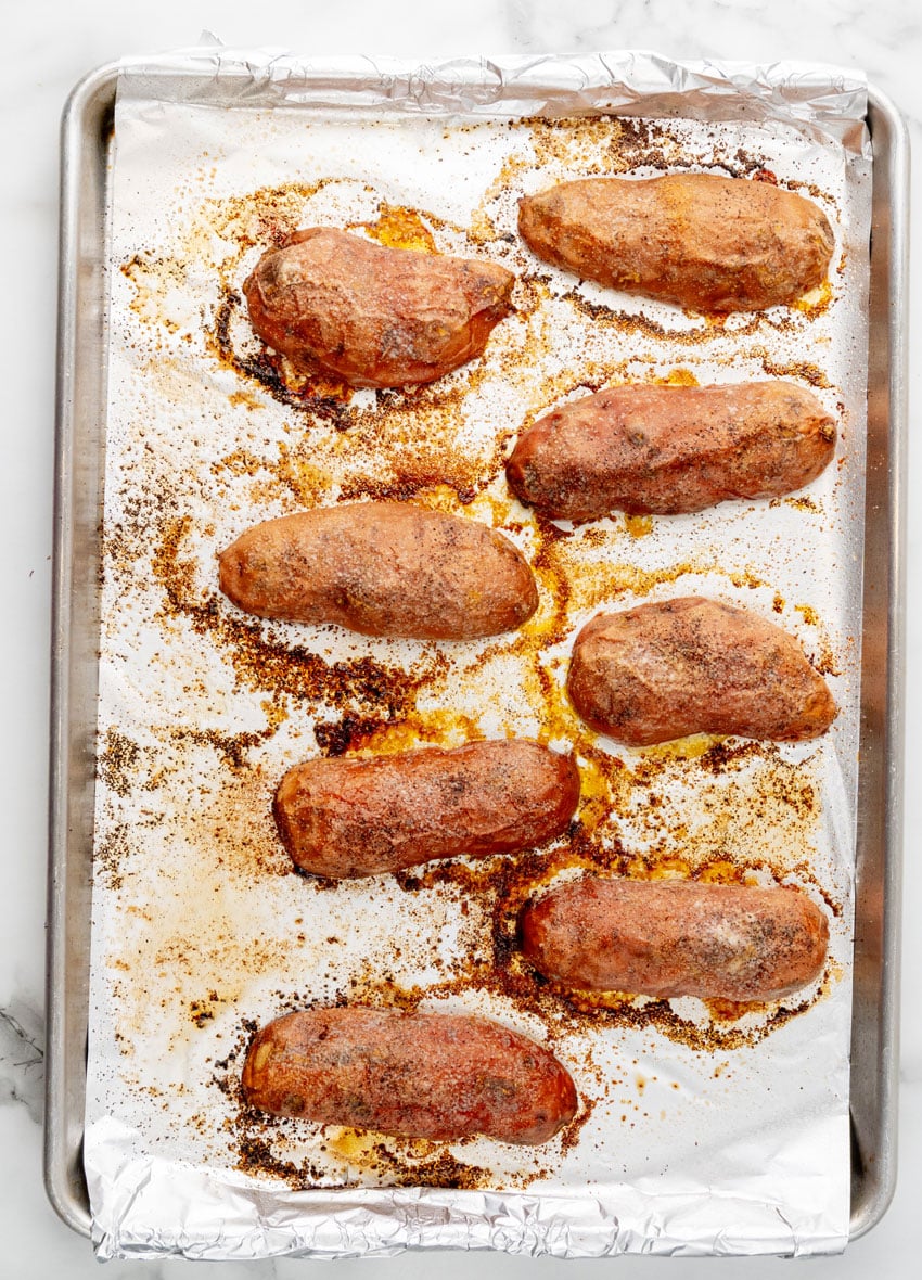 baked roasted sweet potato halves on a foil lined baking sheet