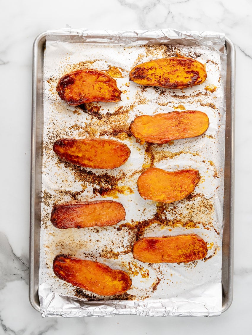baked roasted sweet potato halves on a foil lined baking sheet