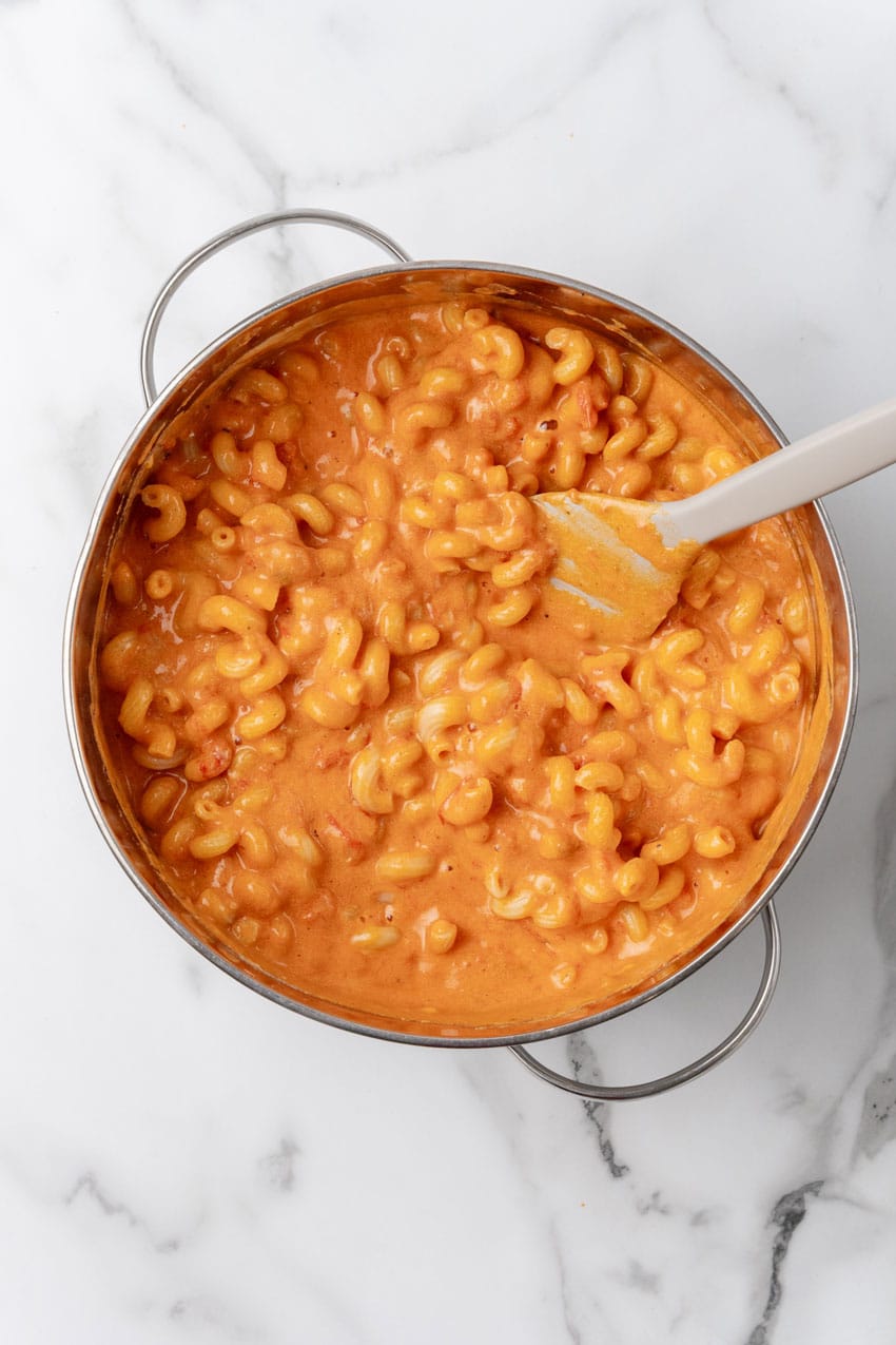 cooked pasta noodles in a creamy tomato sauce in a silver pot