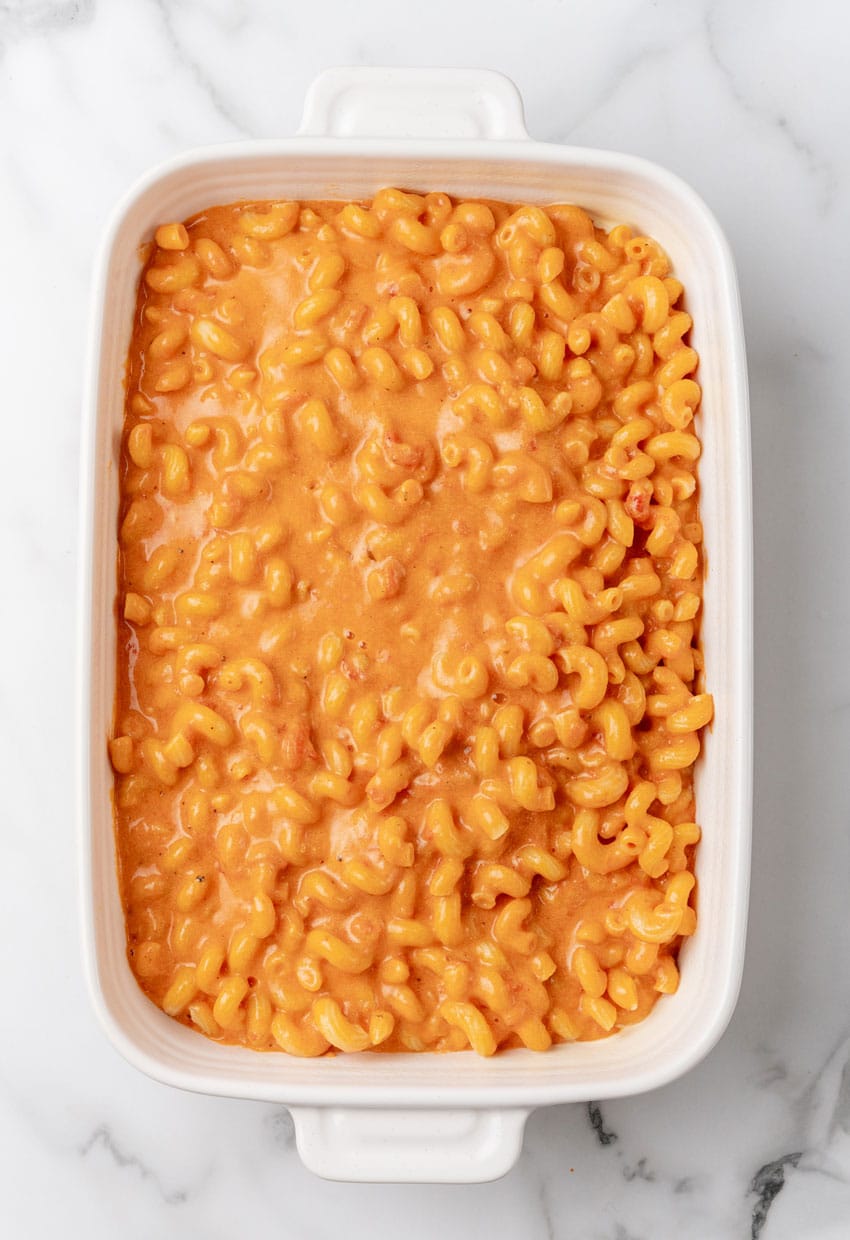 creamy tomato soup mac and cheese in a white baking dish