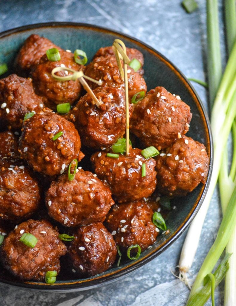 sticky Asian meatballs in a bowl with toothpicks stuck into a few for serving