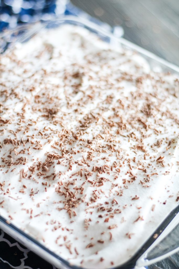 chocolate chip cookie tiramisu served in a glass baking dish and topped with shaved chocolate