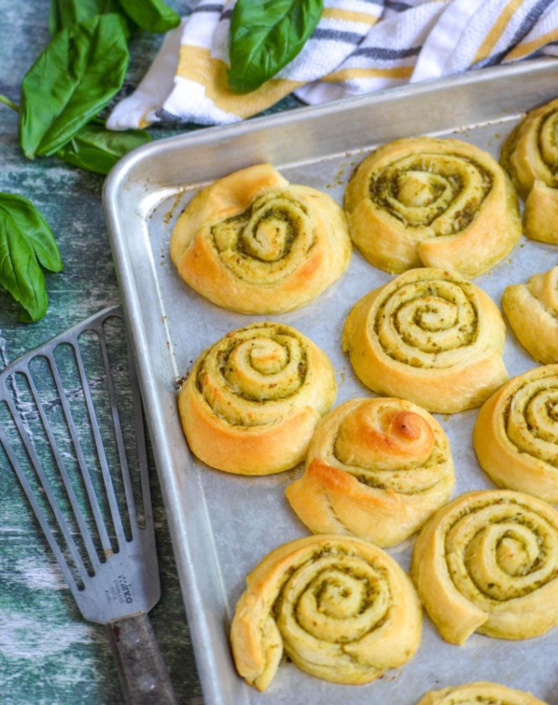 soft buttery pesto lined pinwheels shown on a silver baking tray