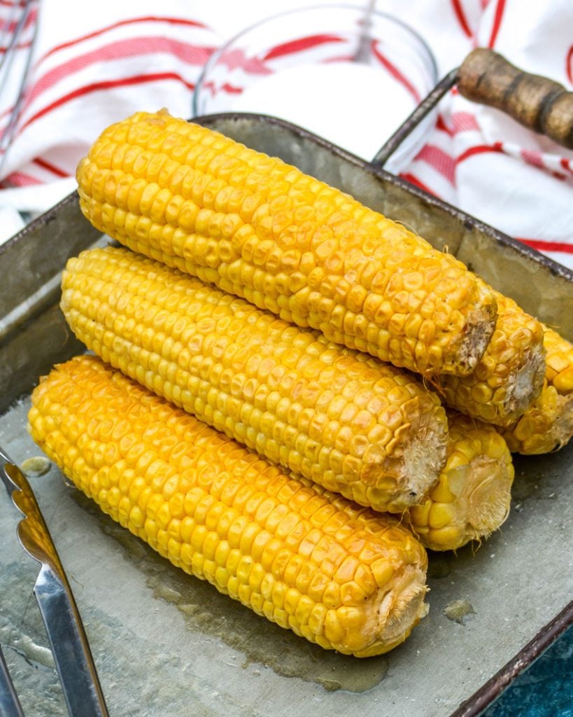 Honey Butter Smoked Corn in a stack on a galvanized metal serving tray