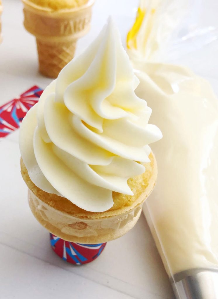 ice cream cone cupcakes are shown with white cake baked in flaky ice cream cone and topped with a tall swirl of white frosting